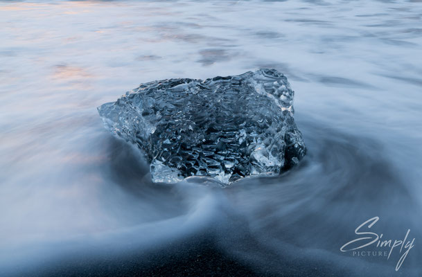 Klare Eisscholle umspühlt vom Meer am Diamond Beach bei dem Jökulsárlón Glacier Lagoon.
