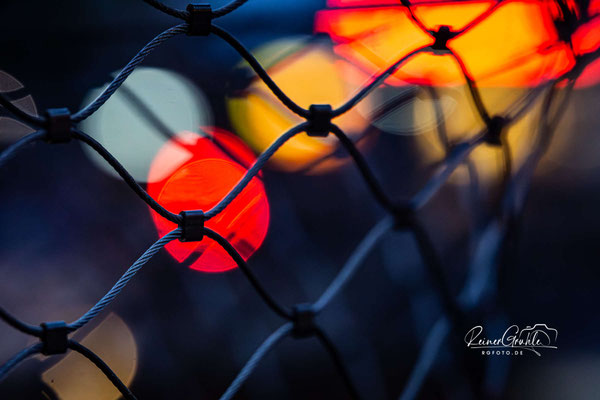 <b>Zaun</b><br>mit Rücklichtern vom Straßenverkehr<br>1/60 | f/3.5 | 90 mm (135 mm) | ISO 3200