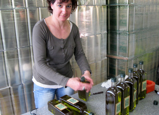 ich beim Etikettieren der Flaschen mit frischem Olivenöl
