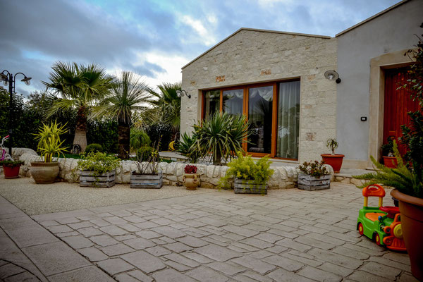 17 Ingresso con giardino fronte casa in pietra / Basole e ghiaia a vista 