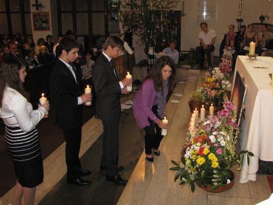 Die 11 Firmlinge stellen ihre Kerzen vor dem Altar auf. Die brennenden Kerzen bilden bis zum Ende der Messe ein stimmungsvolles Bild.