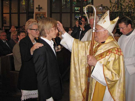 Weihbischof Krätzl spendet das Sakrament der Firmung. Die Paten legen die Hand auf die Schulter des Firmlings.