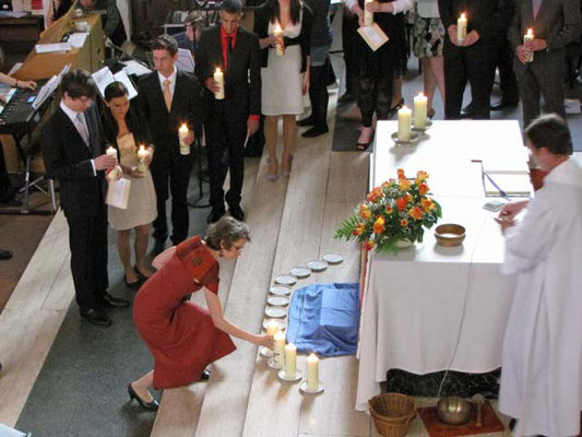 Die 13 Firmlinge stellen ihre Kerzen vor dem Altar auf. Die brennenden Kerzen bilden bis zum Ende der Messe ein stimmungsvolles Bild.