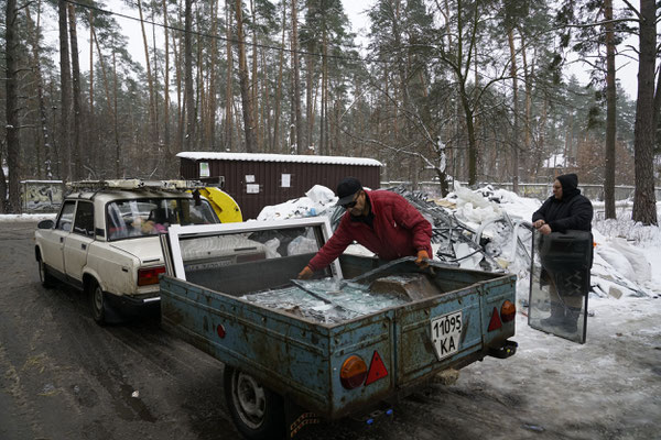 Nikolai and Margarita collecting broken glass from Russian bombings for recycling. Margarita and Nikolai tours the places most devastated by the Russians looking for glass and plastic to recycle and resell. Hostomel.