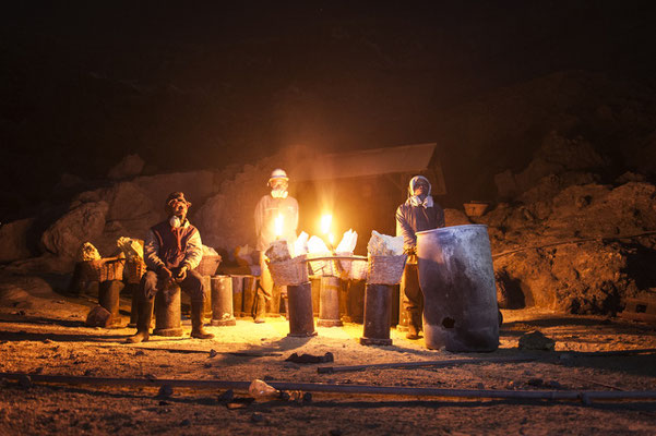 Sulfur miners while resting before climb up the crater of the volcano with their loads during their night shift