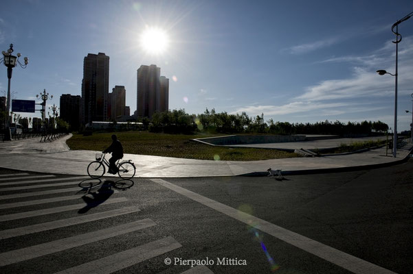 A biker in an empty street of the new district of Kangbashi, Ordos