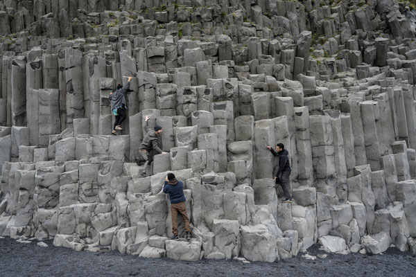 Iceland. Tourists take photos of the famous basalt columns on the Reynisfjara beach. One of the island’s main attractions, Reynisfjara is a black beach that is truly unique.