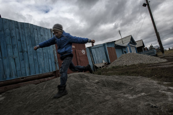 Child playing in the contaminated village of Karabolka