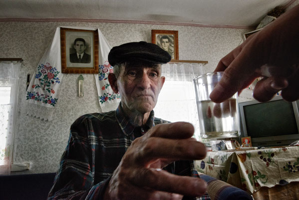 Ivan Ilchinko, 83, while drinking home made vodka in his house, Kupovate, Chernobyl Exclusion Zone