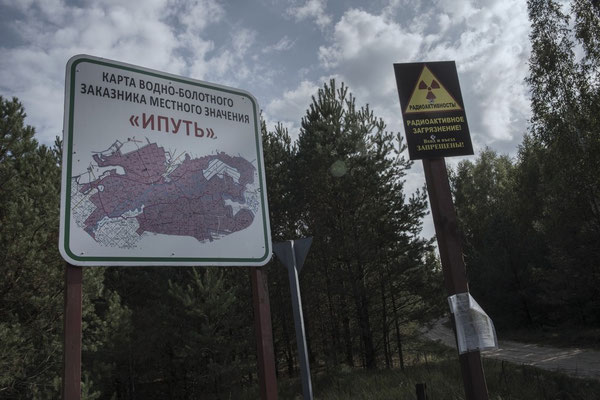 Radioactivity map and sign that warn of the danger of contamination at the entrance to the exclusion zone where the town of Dubovy Log is located.
