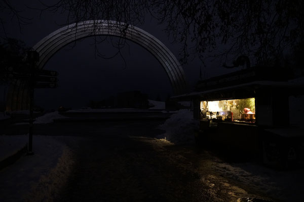 A shop illuminated by a power generator during a blackout in Kyiv in front of the Friendship Arch.  The Arch of Friendship of Peoples is a monument located in Kyiv, and celebrated the friendship between Ukraine and Russia