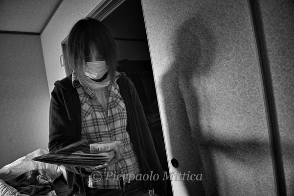 Mutzumi feels depressed collecting her personal belongings in her abandoned house in the Exclusion zone.  Namie city, Fukushima "No-Go Zone", Japan.