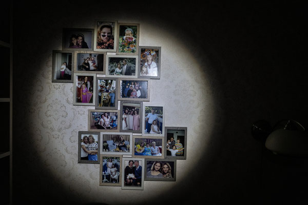 Family photos hung in a house in Horenka illuminated by torchlight due to the total lack of electricity.  Horenka.