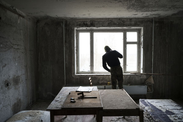 Jimmy checking from the window in his apartment in Pripyat if police is around before leaving