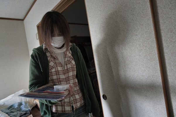 Mutzumi feels depressed collecting her personal belongings in her abandoned house in the Exclusion zone.  Namie city, Fukushima "No-Go Zone", Japan.