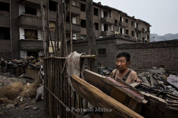 kang jinshan 63 years old lives in the town of Qiabuqi.he worked as a miner from 1992, 3 years ago the government moved all hids family from here because too polluted. But the family has too much members and the new apartment is too small for everyone