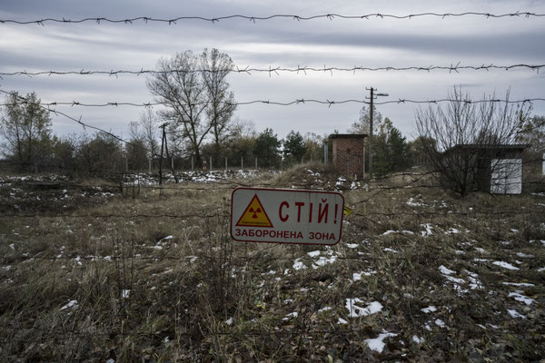 barbed wire that marks the border of the exclusion zone with a sign indicating the contaminated area. Check Point of Dytyatky, Chernobyl Exclusion Zone