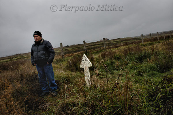Gosman Kabirov, antinuclear activist, next to a radiation sign along the Techa River, evacuated and contaminated village of Muslyumovo