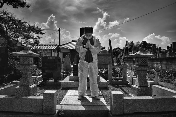 Mister Matsumoto, Yakuza member and Tepco contractor is praying on his family grave, Fukushima "No-Go Zone", Japan.