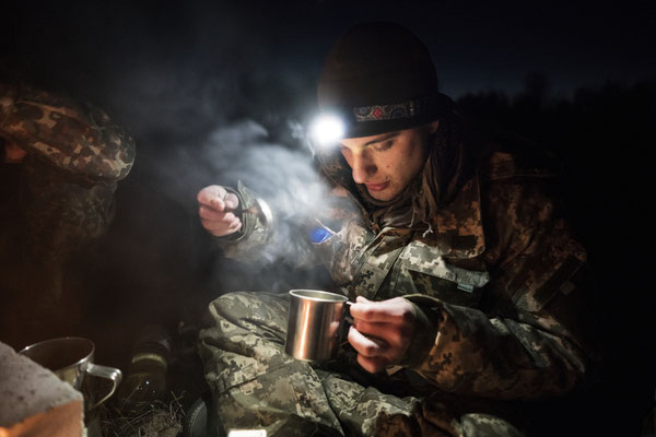 Maxim preparing a cup of tea to get warmer in the abandoned village of Rudnya Veresnya before heading to Pripyat.