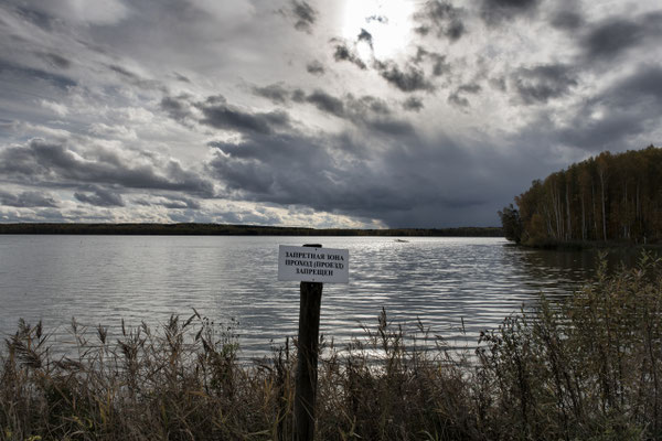Contaminated lake used to discharge plutonium from the nuclear power plant. The sign warns: forbidden area, forbidden access. near Novogorny