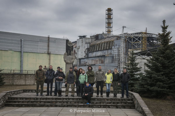 Tourists while taking a picture in front of sarcophagus of reactor number four, Chernobyl nuclear power plant