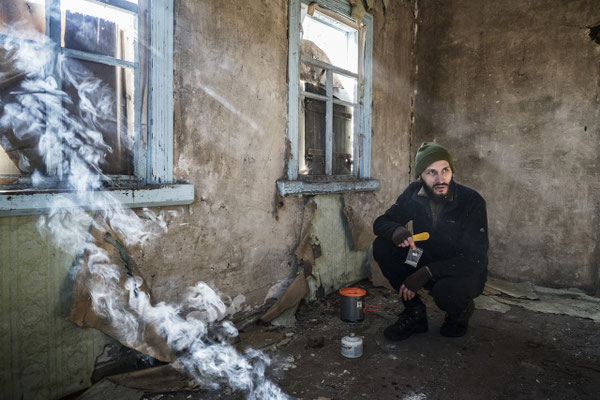 Jimmy preparing breakfast in the abandoned village of Rudnya Veresnya, inside the Zone of exclusion. The village is located 20 km after the border of of the Zone, and it’s the first stop of the stalkers on their way to Pripyat.  