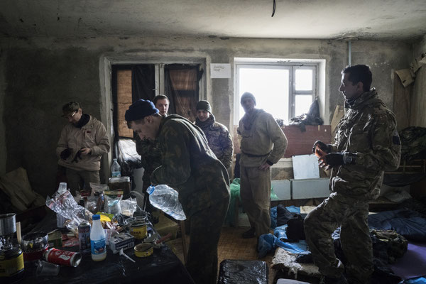 A stalker distributing to the other members of his group the water collected in the flood basement of a building in the ghost town of Pripyat