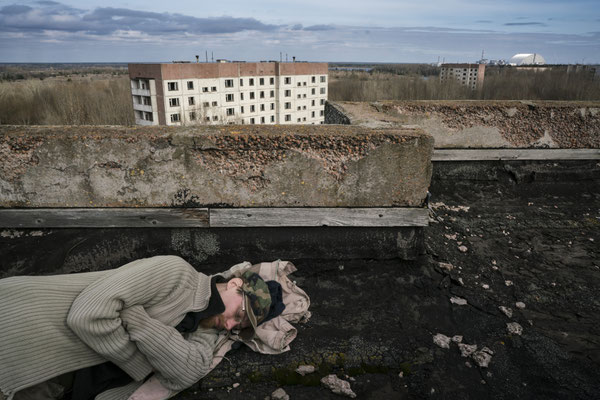Sasha sleeping on the roof of a building in the ghost town of Pripyat. Chernobyl and the unfamous Reactor 4 are on his right, just three kilometres away