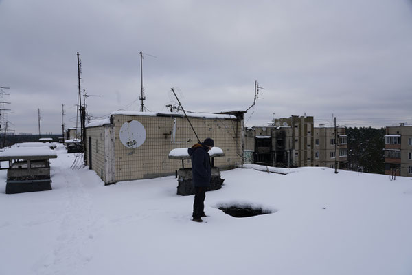 Volodymir Aleksyevic looking at the hole in the roof of his house caused by a Russian mortar shell.  Volodymir's flat was destroyed in the first days of the war when the Russians occupied Irpin. He has been living without electricity, water and heating ev