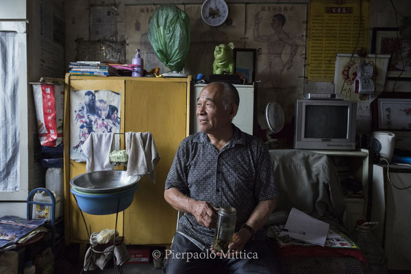 Mr Wang, a masseur, waits for some clients in the semi-evacuated town of Gongwusu