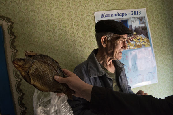 Ivan Ilchinko and a smoked fish as a winter stock pile. Ivan died on 2019. Kupovate, Chernobyl Exclusion Zone.