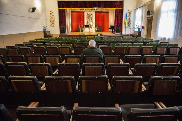 Chernobyl town. A man waits for a show to begin at the House of Culture, where events such as concerts, recitals, conferences and meetings are organize for the entertainment of the population.