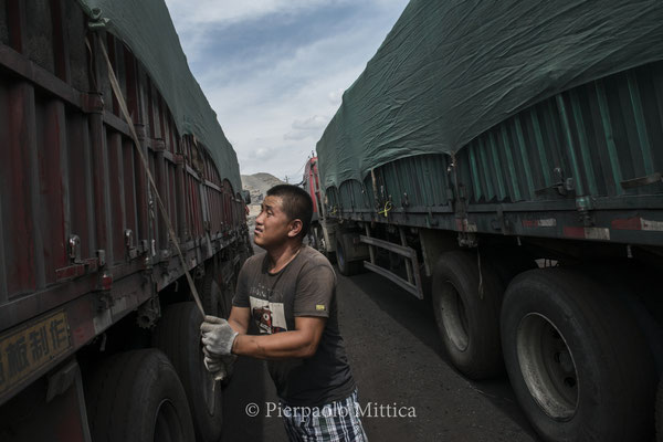 A truck driver checking the coal load before leaving