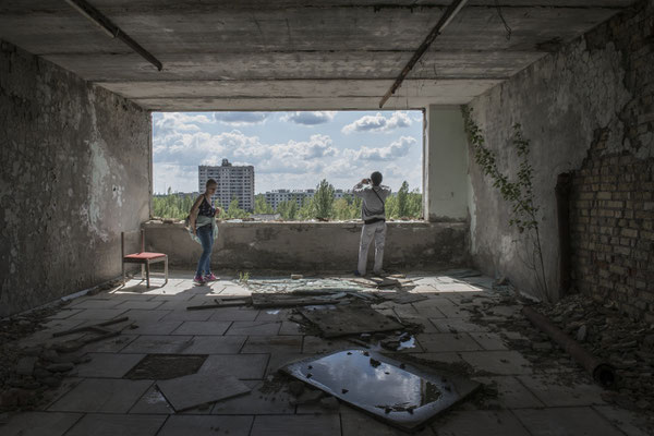 Former inhabitants of the city of Pripyat taking souvenir photos from the top floor of the Polessya hotel, in the main square of the city of Pripyat.