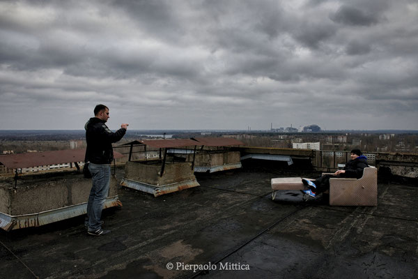 Alexsey while taking a picture to another participant of the tour, on the roof of a building in Pripyat, exclusion zone. Aleksey is from Odessa and came to Chernobyl because he wanted to see how it was a city in the Soviet era