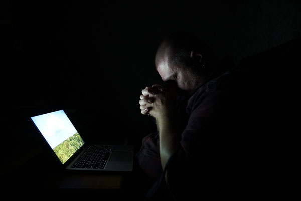 Anton Yuhimenko in his home while working on his computer during a power blackout.  In his neighbourhood, electricity is rationed and comes on about four hours a day. On some days it even fails for more than 30 hours. 