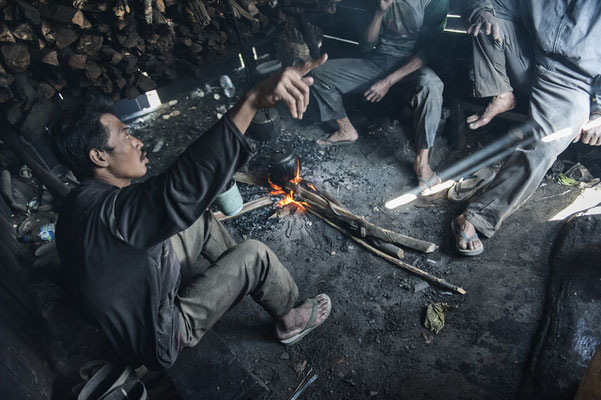 miners while resting and eating in a barrack located on the path that leads to the top of the volcano