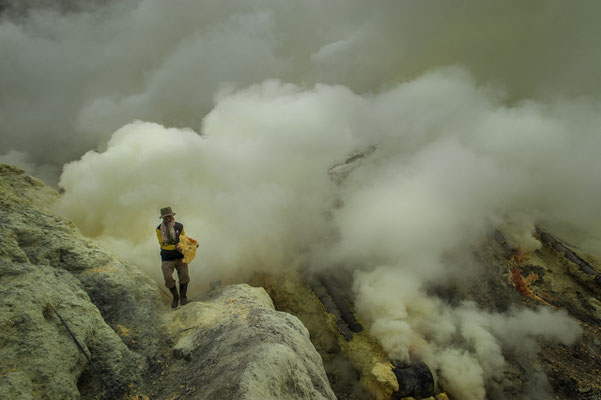 a miner while collecting chunks of sulphur in the volcano crater