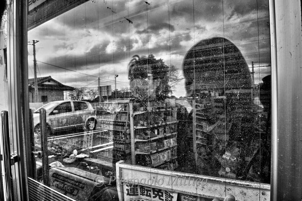 Yoshida and his wife Mutzumi looking inside the market where they met the first time, Tomioka City, Fukushima "No-Go Zone", Japan.