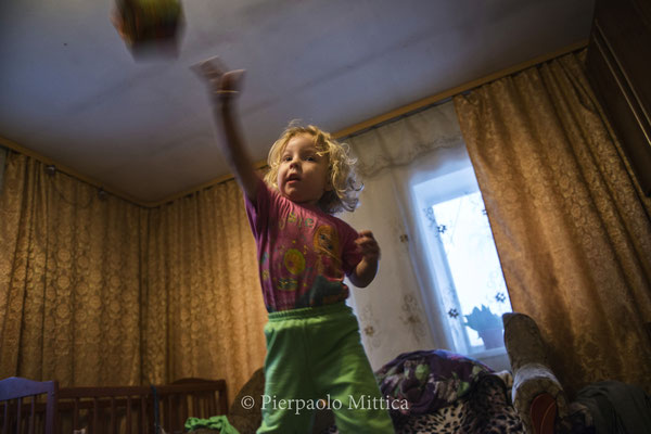 Victoria, 3 yo, playing at home. She’s the daughter of Victor, the manager of the site where radioactive metal is recycled.  The whole family lives in the village of Kovalivka, located at 5 km from the Chernobyl Exclusion Zone