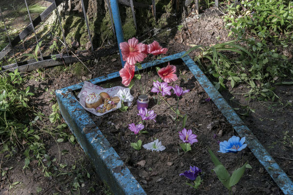 a tomb with flowers and ornaments in the Chernobyl cemetery