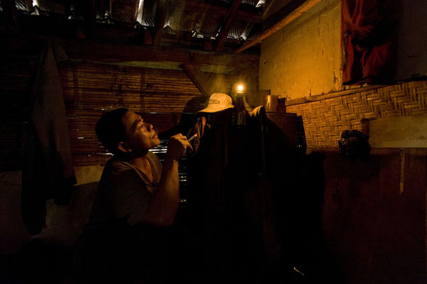 Imik, lives in Glondak village, here he is smoking and resting in the dimmed room before leaving for his night shift