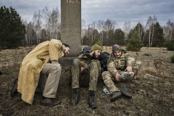 Sasha, Jimmy and Maxim during a pause of their journey to Pripyat while checking their feet filled with blisters for their long walk.