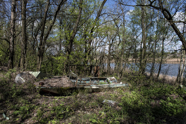 An abandoned boat wrapped in nature in the Yacht club of the ghost town of Pripyat.