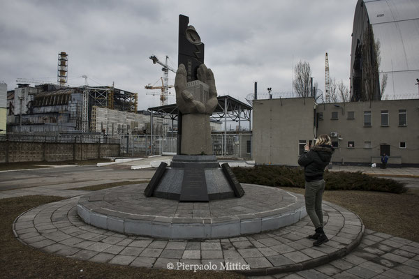 a Tourist in front of sarcophagus of reactor number four, Chernobyl nuclear power plant