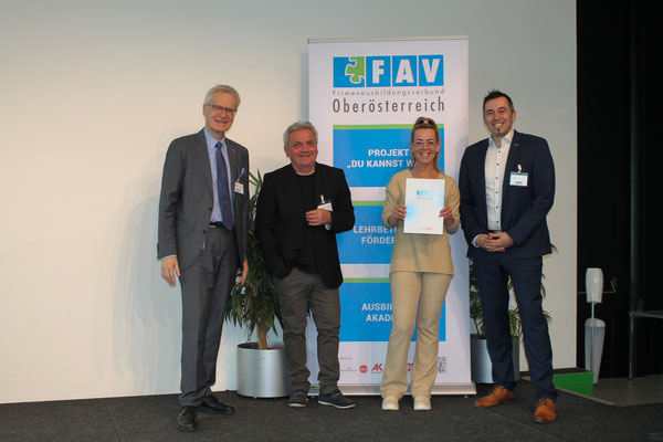 Absolventin erhält Anerkennungsurkunde auf der Bühne