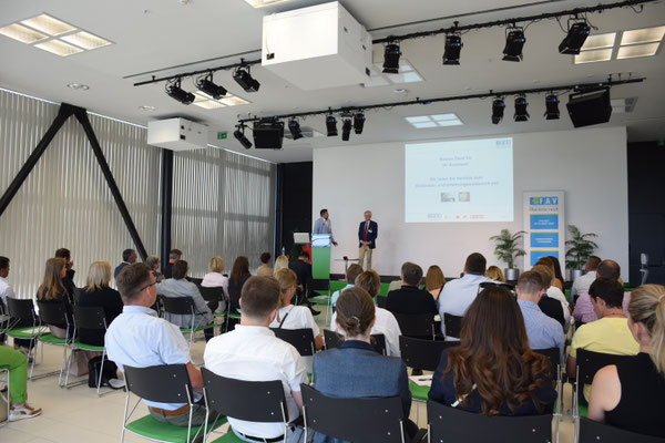 Publikum verfolgt Präsentation im modernen Saal