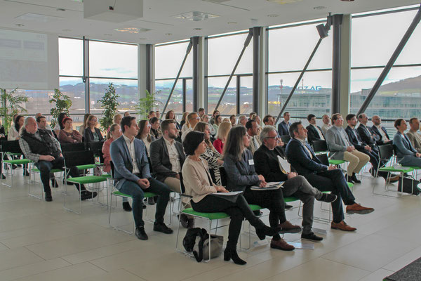 Publikum bei der Veranstaltung im modernen, lichtdurchfluteten Raum