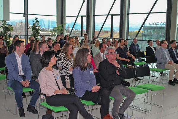 Aufmerksame Zuhörer:innen mit Blickrichtung Bühne